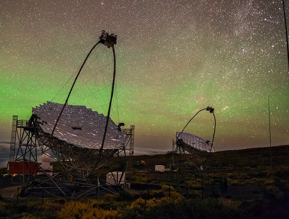 The Major Atmospheric Gamma Imaging Cherenkov Telescopes point to a starry night sky in the Canary Islands.