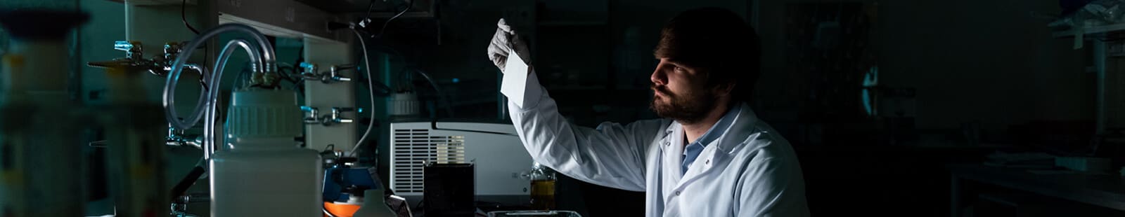 A person works in a darkly lit laboratory