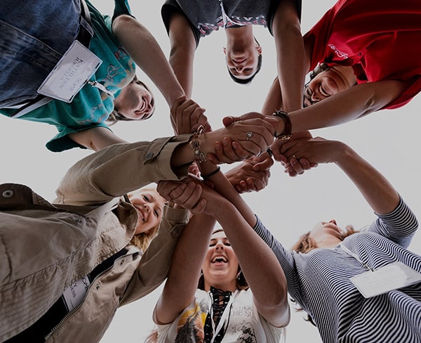 UW–Madison SOAR Program student group in a circle joining hands. Viewed from below.