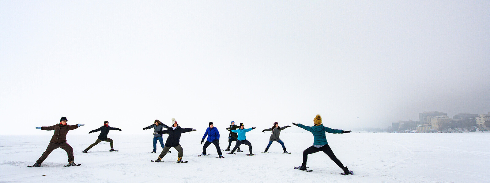 A group of students practice yoga on a frozen Lake Mendota.