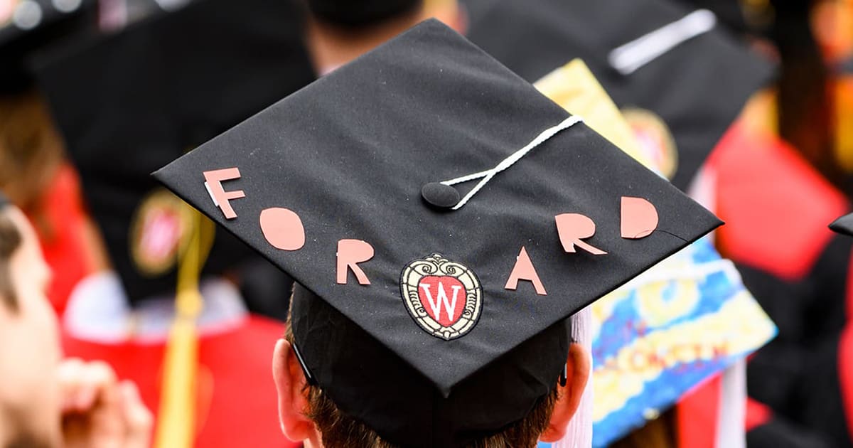 A graduation cap is decorated with the word Forward.