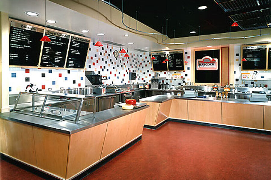 Decorative tiled white wall with colorful checkers positioned behind food and sales counter.