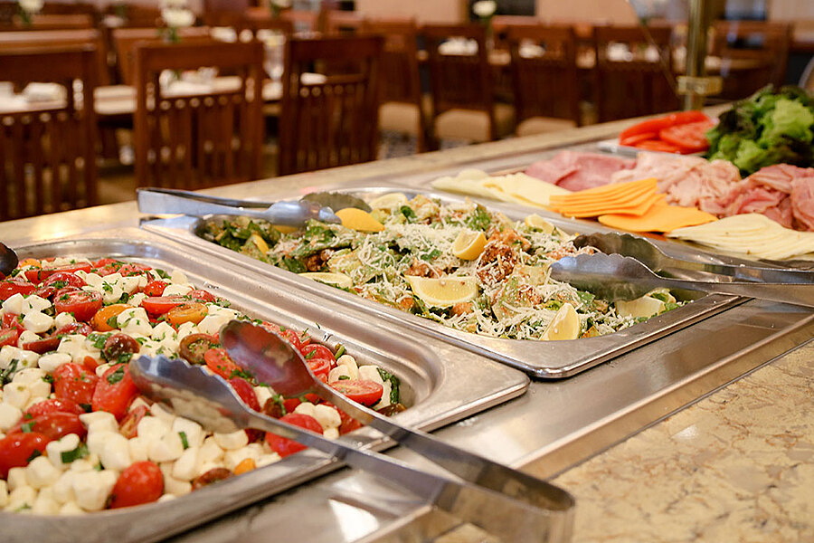 Salad bar in foreground of dining room.