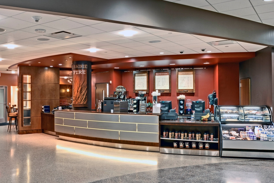 Large sales counter with self-serve items including food, beverages and coffee tumblers. 