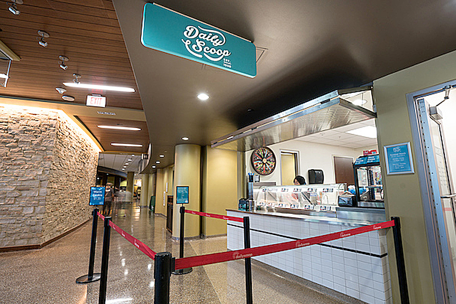 Ice cream counter with stanchion and Daily Scoop sign fixed to ceiling. 