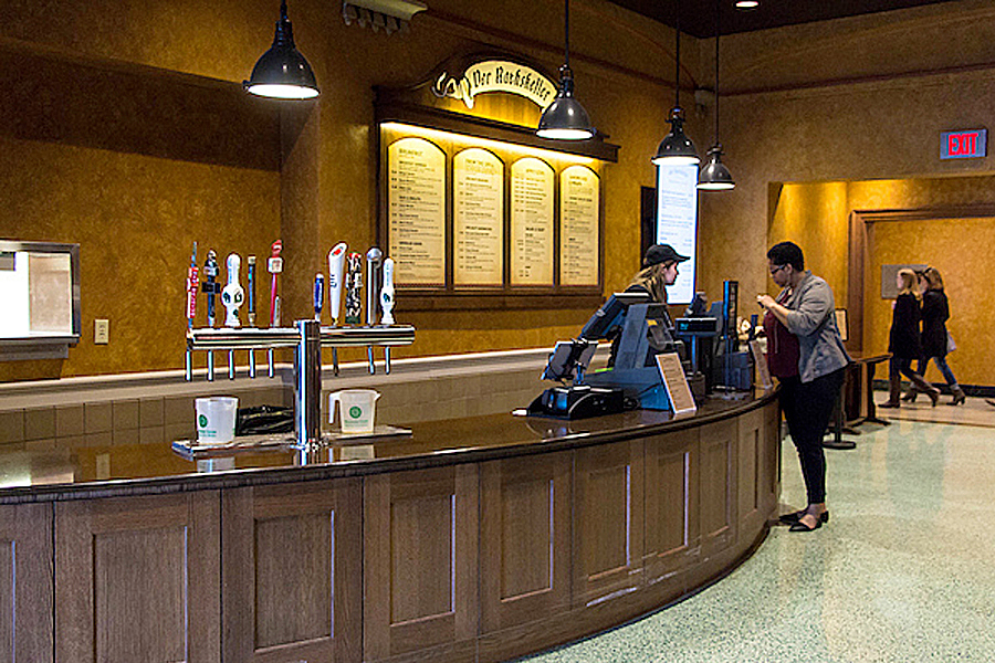 Person ordering at sales counter with row of beer taps in foreground. 