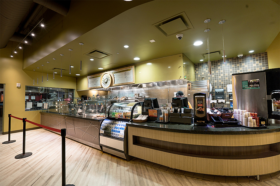 Food station and self-serve beverage stand leading up to sales counter.