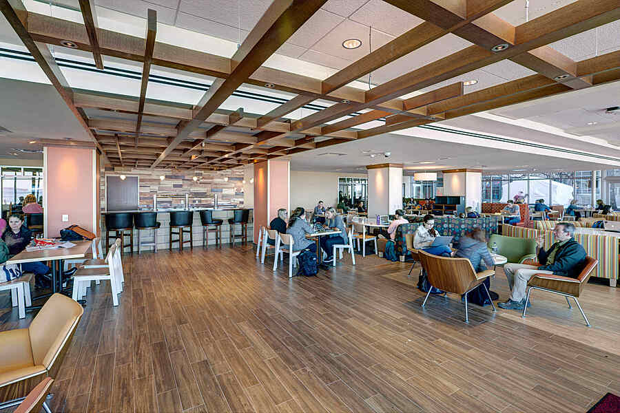 People seated in bright dining room with decorative wooden beams attached to ceiling. 