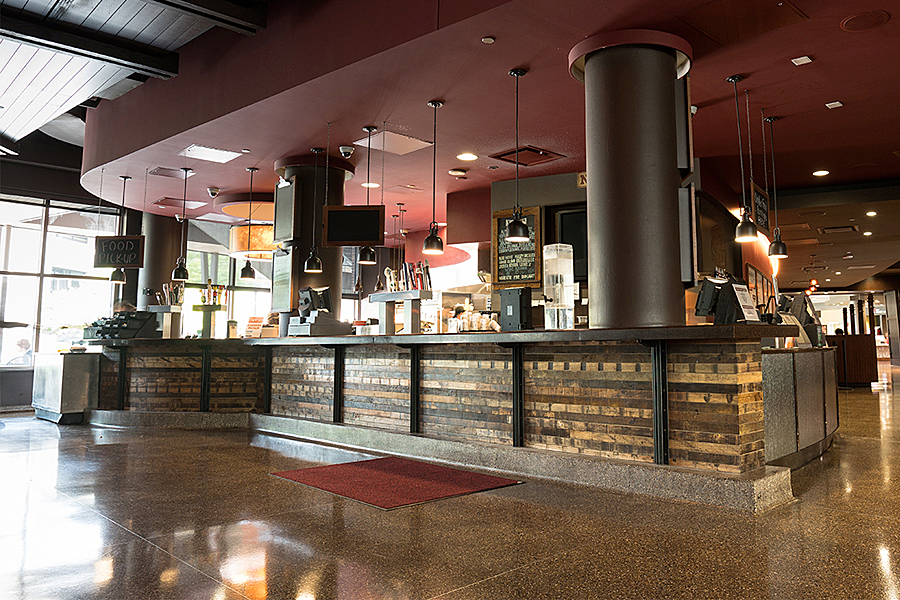 Brick-lined sales and pick-up counter within dimly lit pub-style venue. 