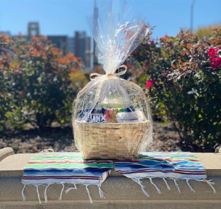 A gift basket with items wrapped in decorative cellophane.