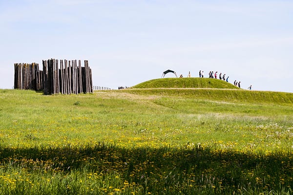 A class observes the burial mounds in a large grassy area at Aztalan State Park.