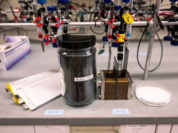 A chemistry bench with electrodes, spent batteries and recovered lithium.