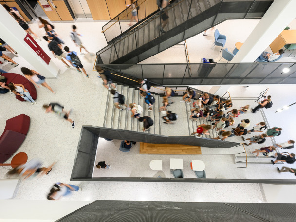 Students walk to class in a view from the top of the stairs in Irving and Dorothy Levy Hall.