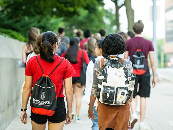 Incoming students wearing backpacks walk down W. Dayton St.