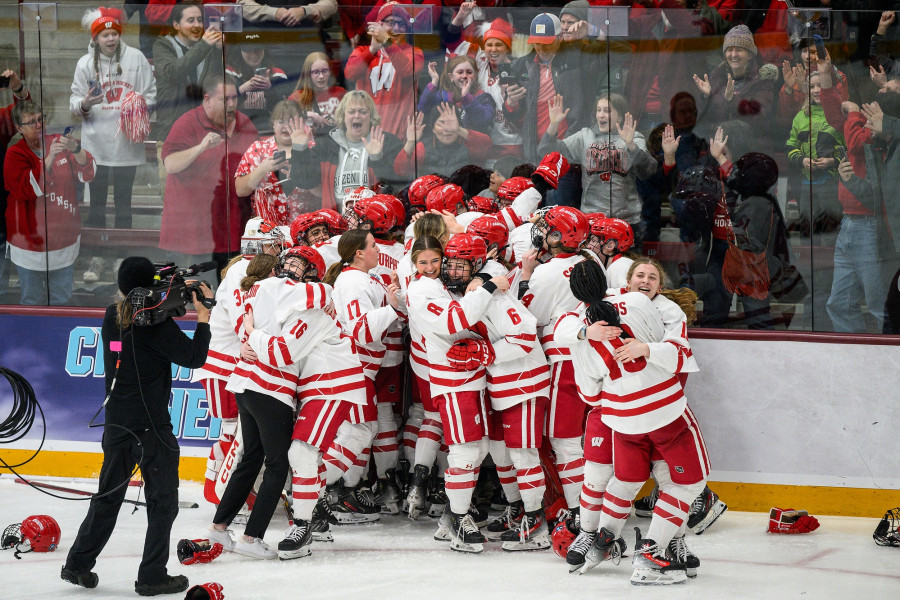 The team of women's hockey players hug each other on the ice immediately after winning the championship.