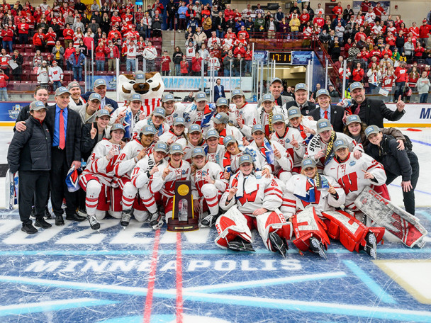 The team of women's hockey players hug each other on the ice immediately after winning the championship.