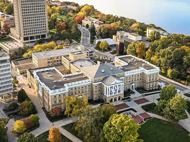 An aerial photo of the UW–Madison campus shows Bascom Hall in the foreground and Lake Mendota in the background.
