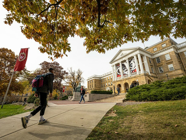 A student walks up Bascom Hill on a fall day.