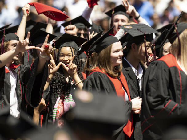 A crowd of celebrating UW graduates stand to receive their degrees at spring commencement