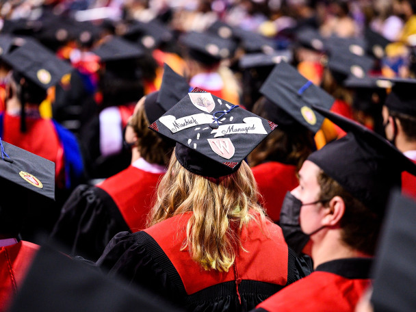 A shot behind of a crowd of UW students in commencement regalia.
