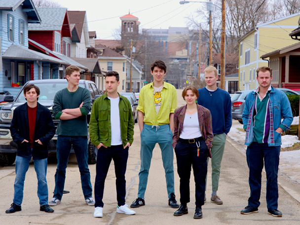 Member of the band East of Vilas are shown standing in a street just off campus.