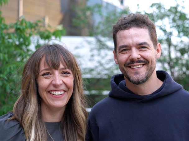 Meagan Hahn and Shawn Wiederhoeft stand together outdoors, smiling.