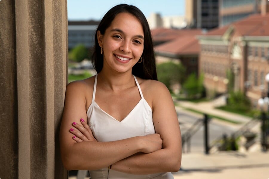 Natalia Betancourt Rodriguez poses in a window, with the UW Campus behind her.