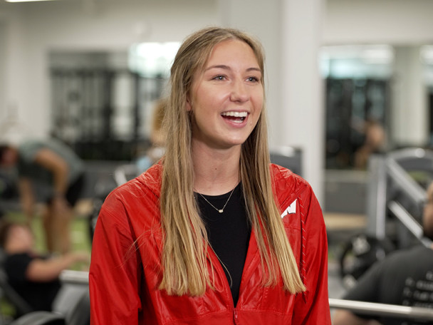 A portrait photo of Samantha Mahlum wearing a red Badger hoodie, laughing and smiling.