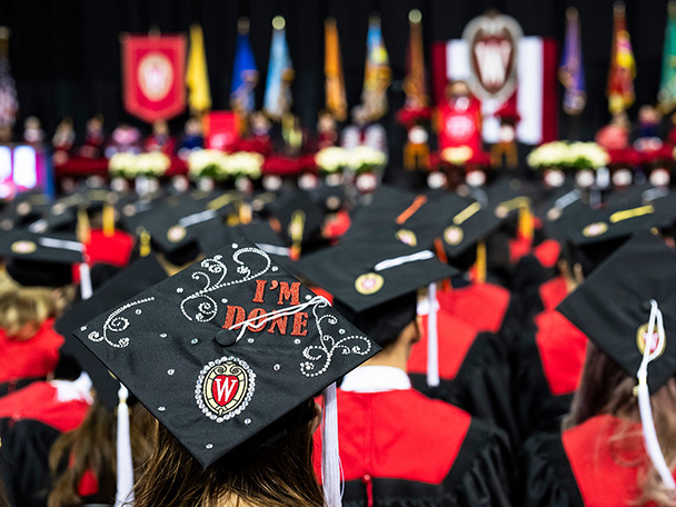 A commencement cap in a sea of others has the phrase 'I'm done' and a UW logo on it.