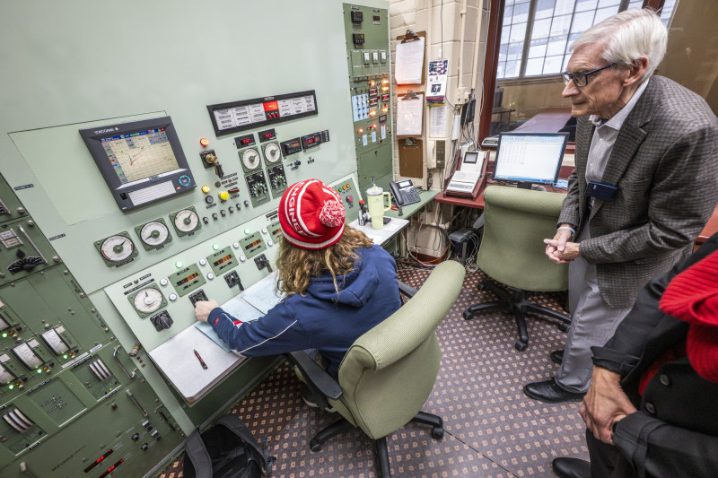 Governor Evers watches as an undergraduate student operates the nuclear reactor panel.
