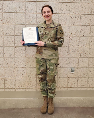 Jolene Anders in uniform, holding a certificate of promotion.